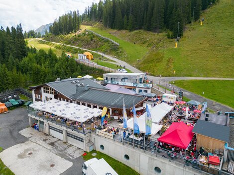 A popular mountain restaurant with a large terrace and many guests. Surrounded by forests and mountains, it offers a beautiful view. | © Christian Barz