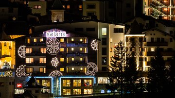 A building with bright Christmas decorations in an urban setting at night. The name "Solaria" is clearly visible and the atmosphere feels festive.