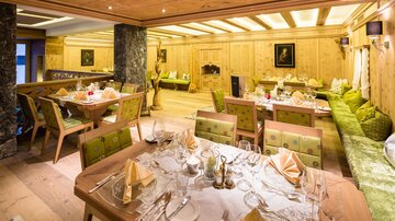 A cozy restaurant with wooden interiors and elegant table settings. The atmosphere is warm and inviting, perfect for a special meal.